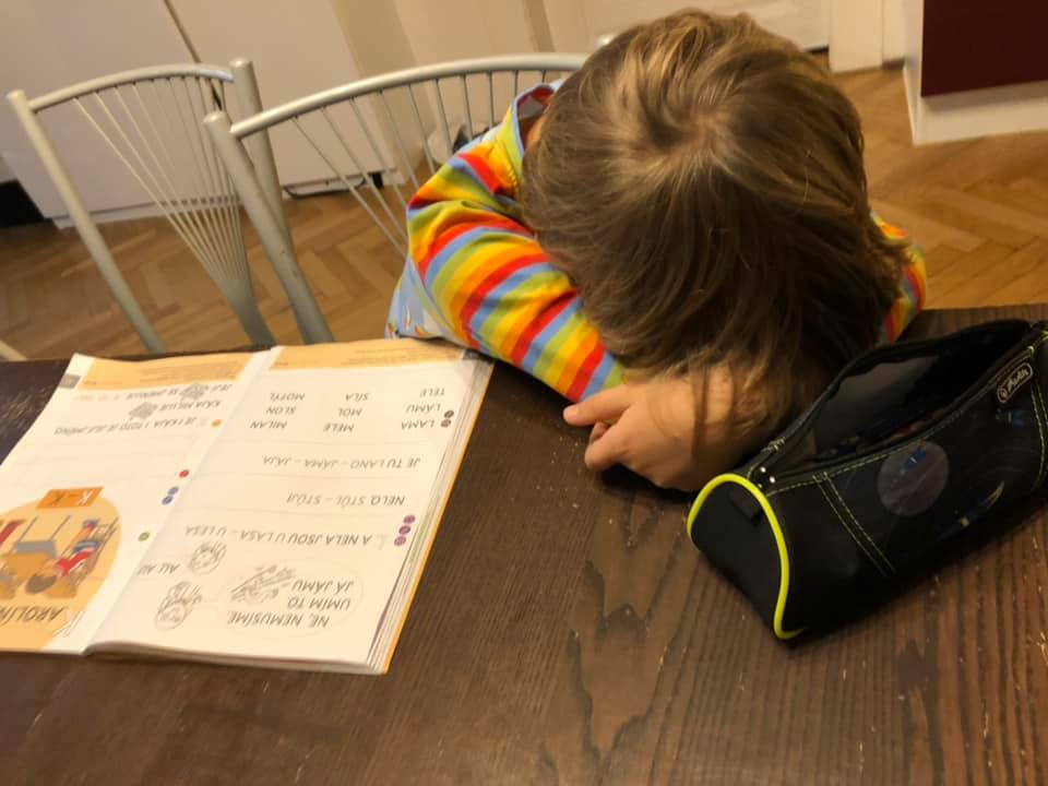 Dítě složené hlavou na pracovním sešitě - učení ho nebaví